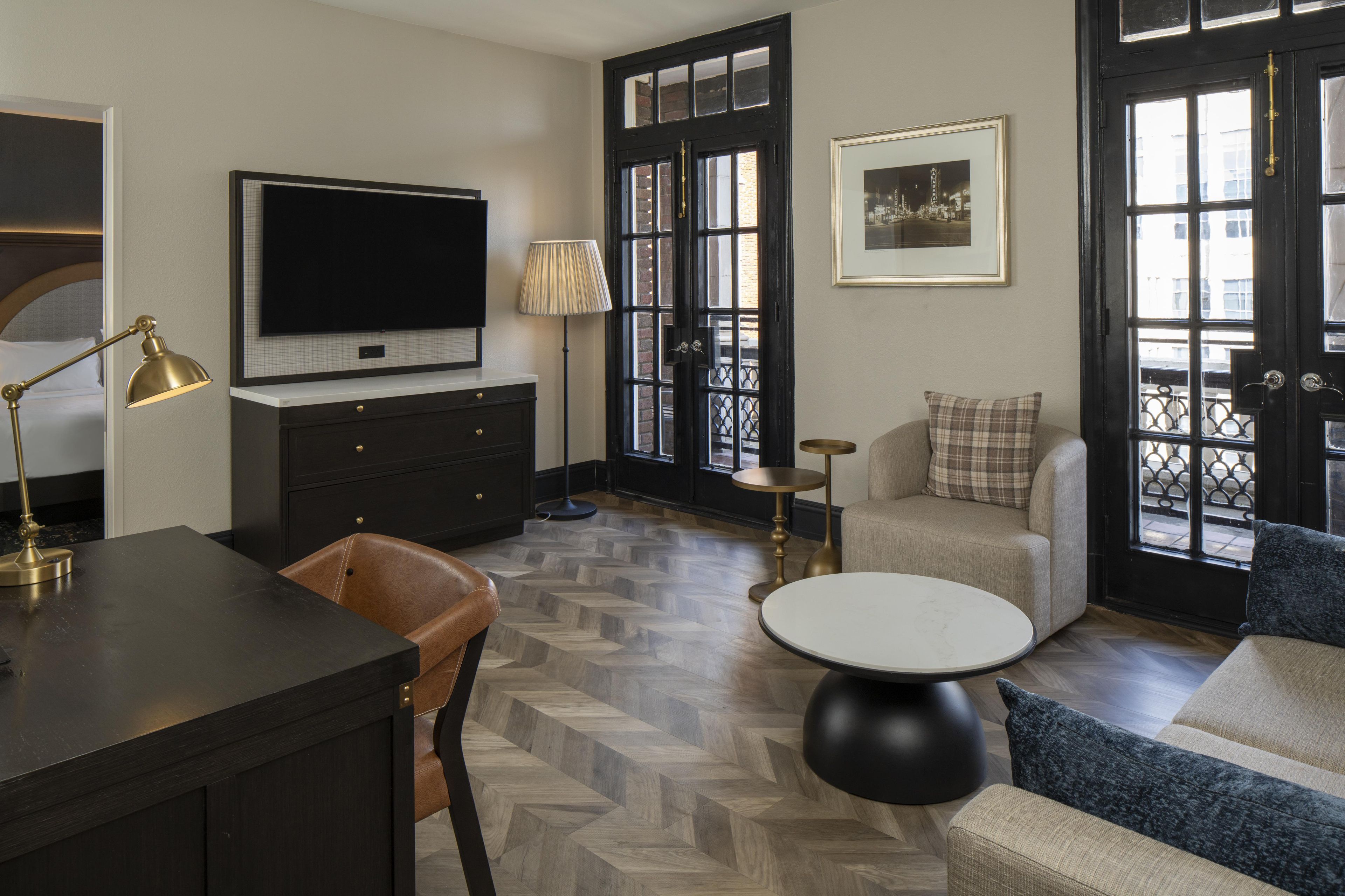 A modern living room with a flat-screen TV, a coffee table, a sofa, and a chair.
