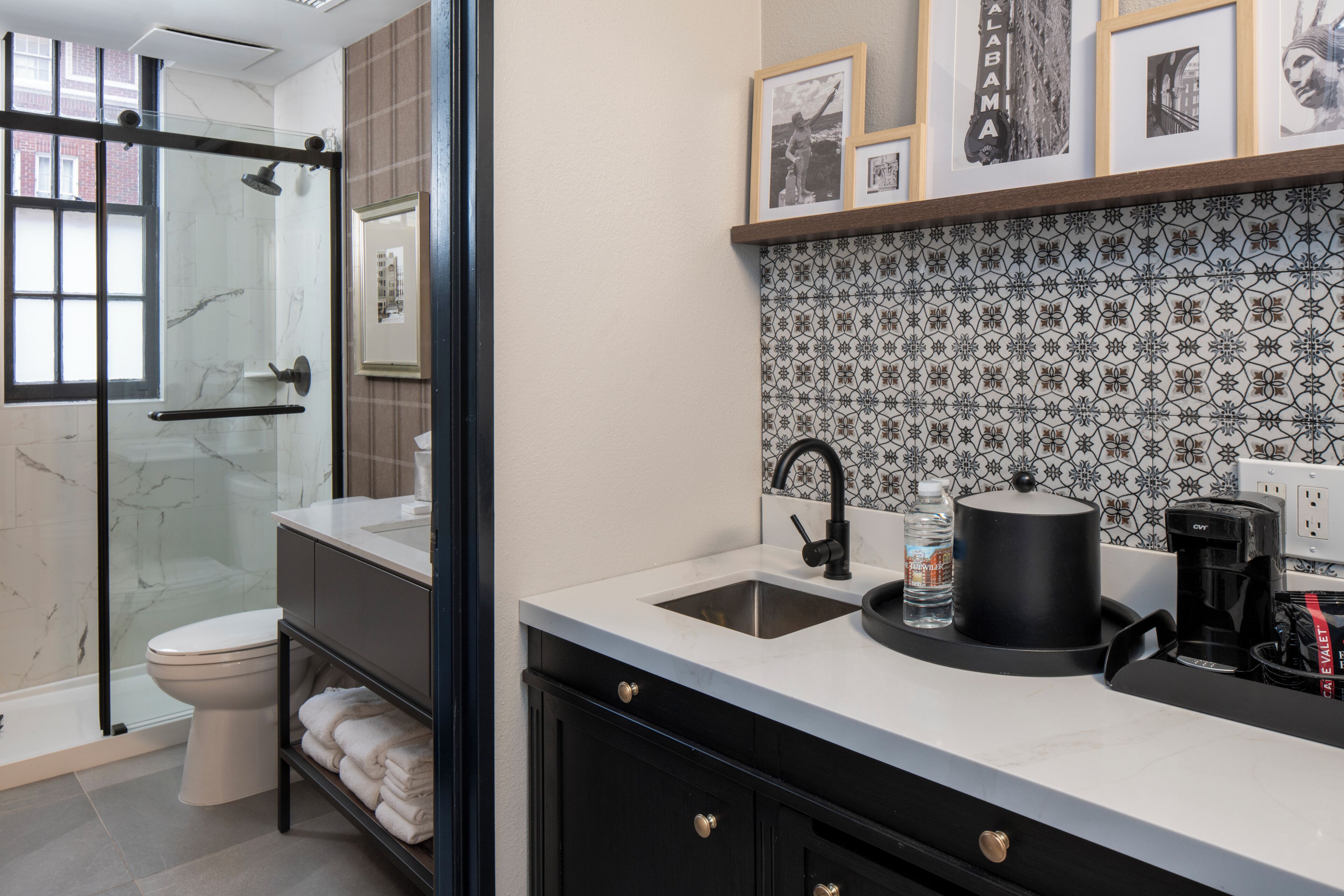 A modern bathroom with a glass shower enclosure, a white toilet, and a black vanity with a sink.