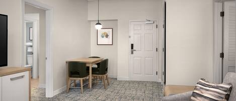 A compact living space with a kitchenette, a dining area with a table and chairs, a sofa, and a television.