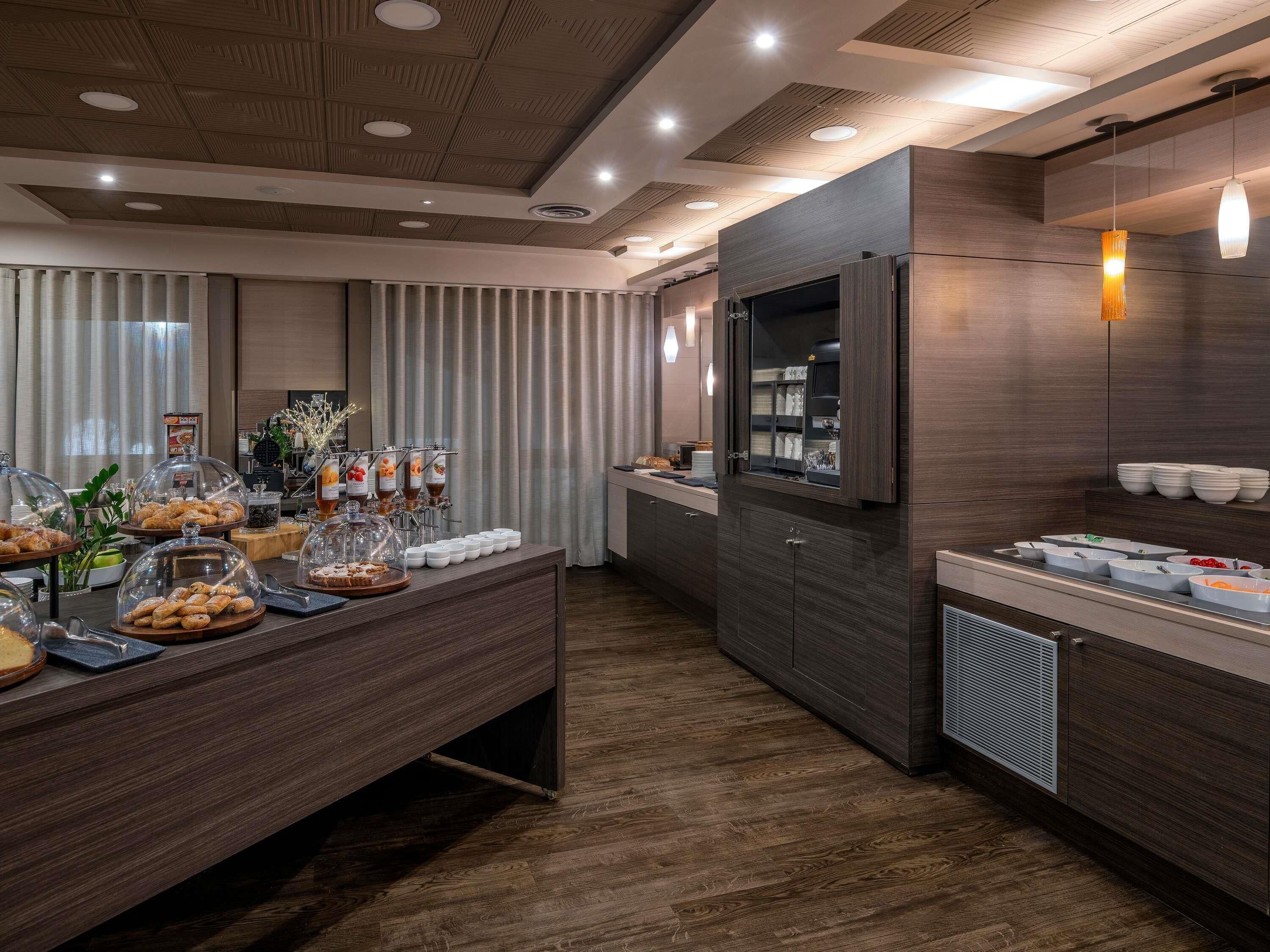 A modern breakfast buffet with a variety of food items and a coffee station.