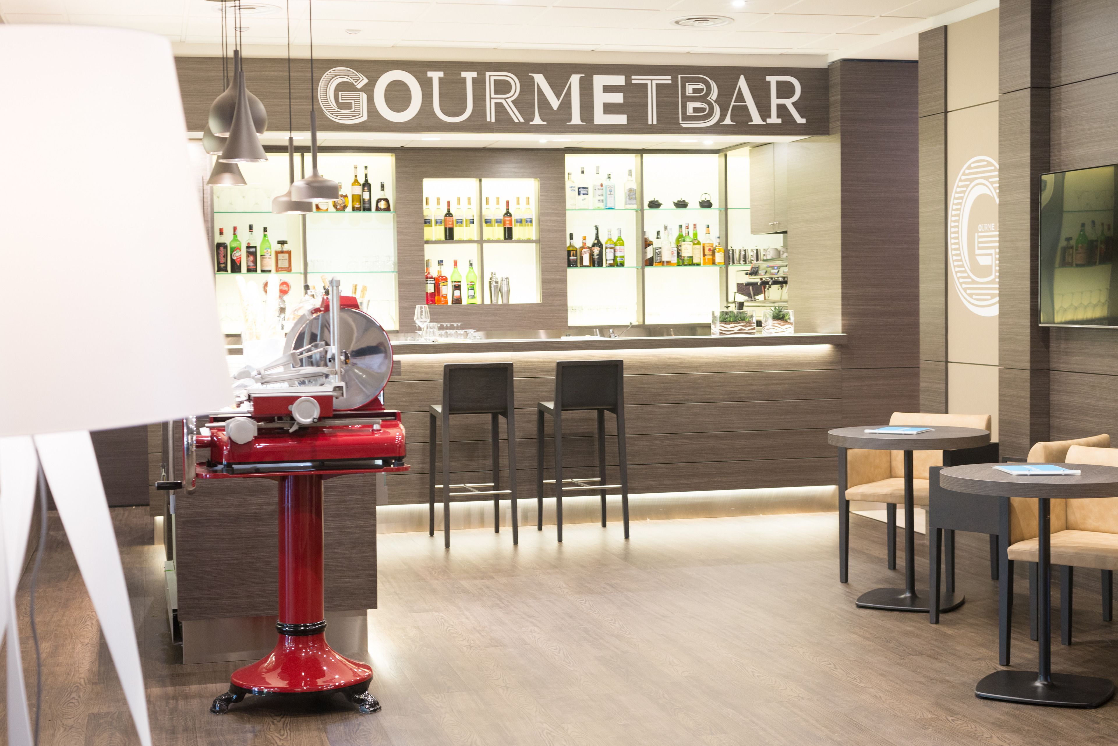 A bar area with a counter, chairs, and a red machine.