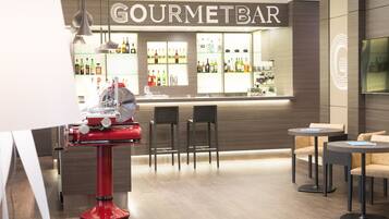 A bar area with a counter, chairs, and a red machine.