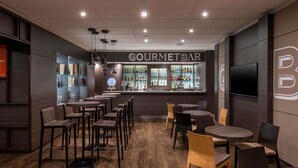 A restaurant interior with a bar area, wooden flooring, and modern lighting. - Novotel Brescia 2 (Brescia)