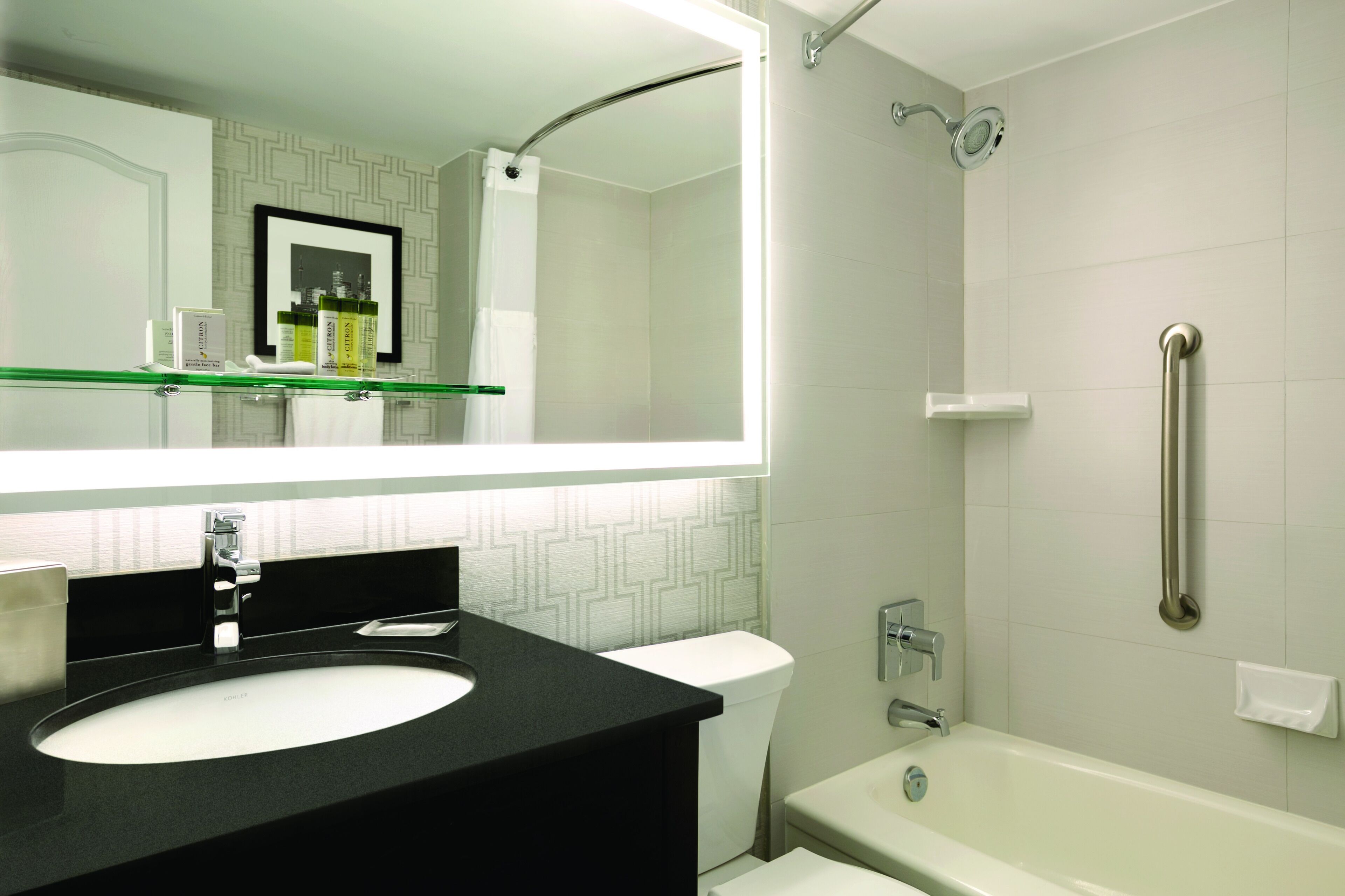 Un baño moderno con un lavabo negro, un inodoro blanco y una bañera.