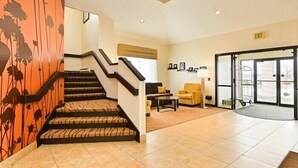 A hotel lobby with a staircase, a reception desk, and a seating area. - Sleep Inn Billings (Billings)
