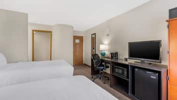 Habitación de hotel con dos camas, un escritorio, televisión, microondas y refrigerador.