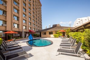 Alberca al aire libre, sombrillas en la alberca y camastros 