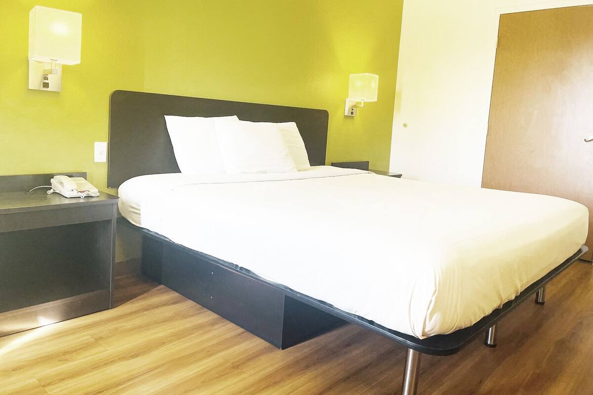 Ein Hotelzimmer mit einem Bett, Nachttischen und einem Telefon.