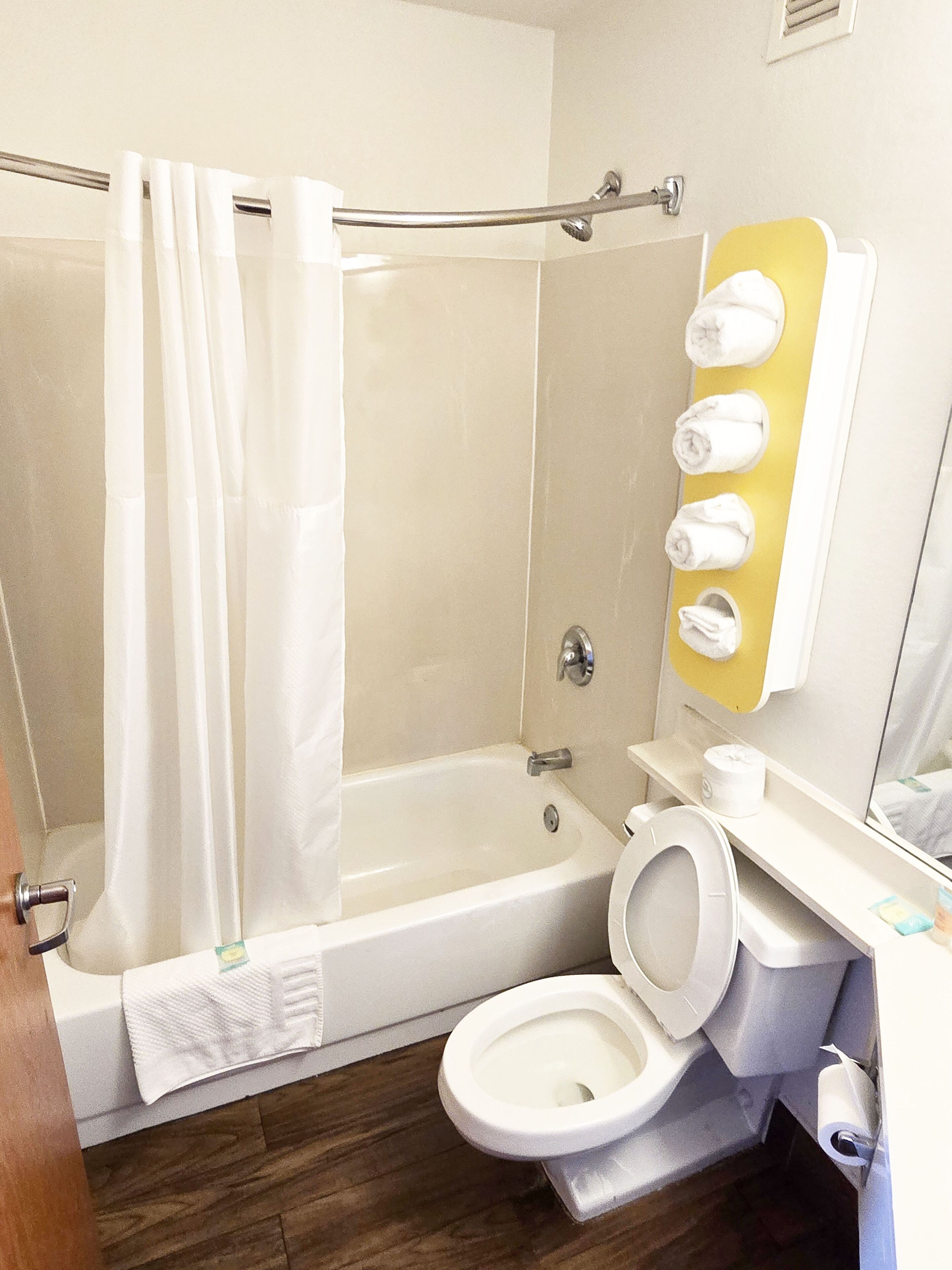 A bathroom with a shower, toilet, and sink.