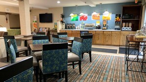 A hotel lobby with seating areas, a counter with food and drink options, and a television. - Quality Inn near Toms River Corporate Park (Manchester Township)