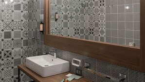 A bathroom with a white sink, a wooden vanity, a large mirror, and patterned tiles.