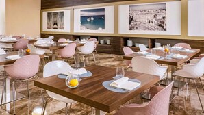 A restaurant with multiple tables, each set with white plates, cutlery, and glasses.