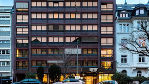 Un hotel de varios pisos con fachada moderna, amplias ventanas y una entrada visible.
