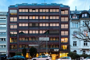 A multi-story hotel with a modern facade, large windows, and a visible entrance. - Garner Hotel Frankfurt Palmengarten by IHG (Frankfurt)