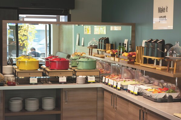A buffet area with various food items and kitchenware.