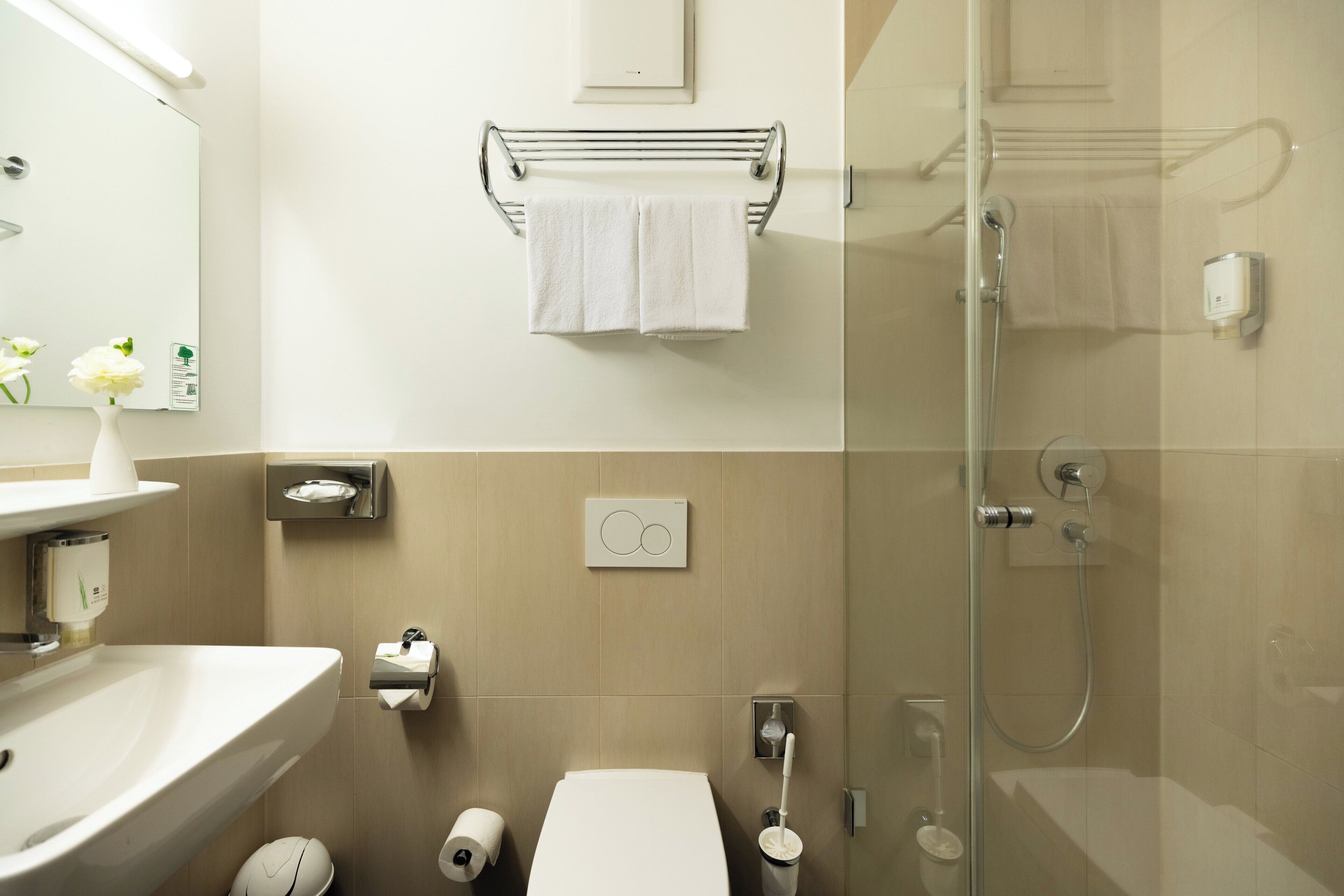 A modern bathroom with a sink, toilet, and glass shower enclosure.