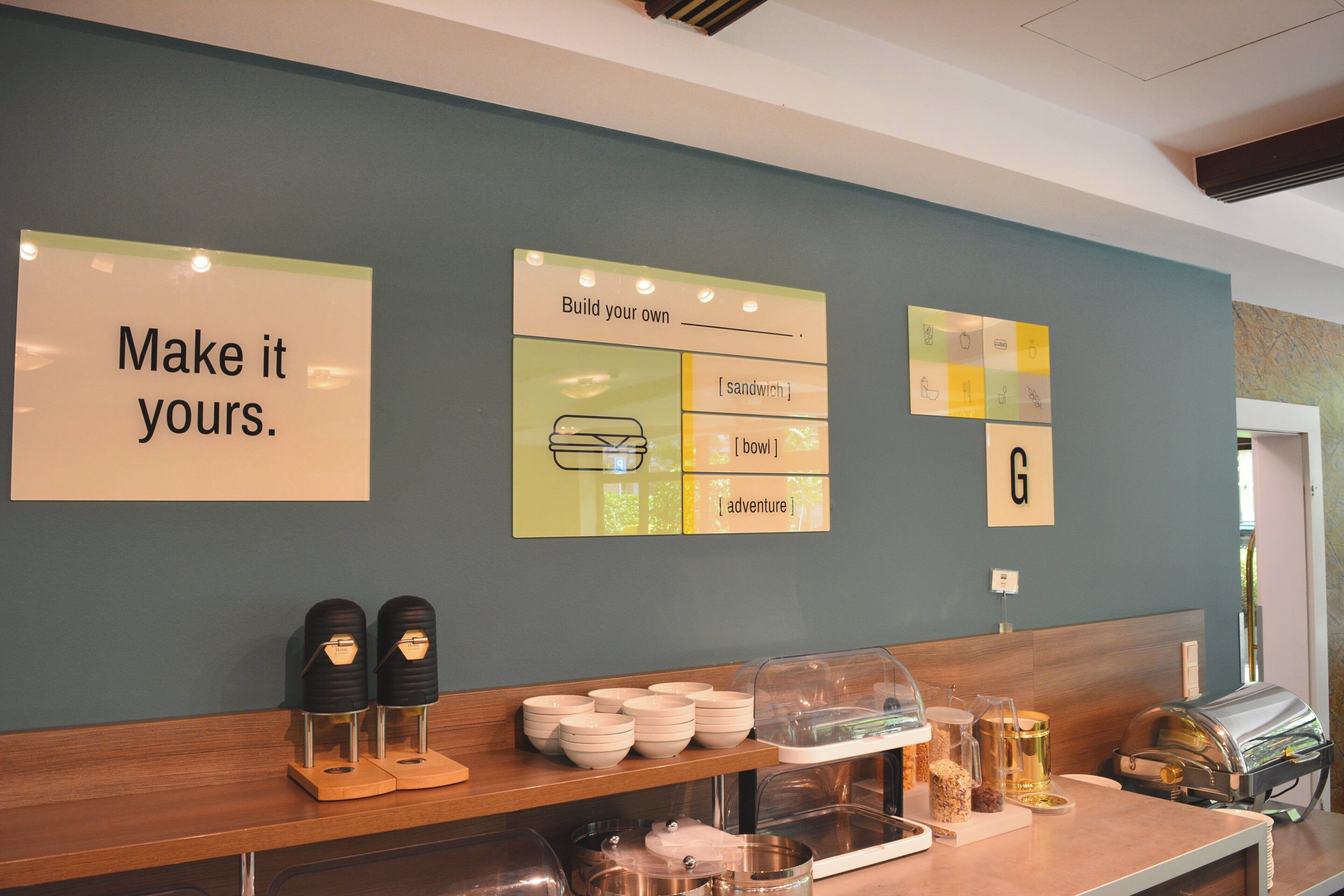 A counter with a sign that reads 'Make it yours.' and a wall with various labeled sticky notes.