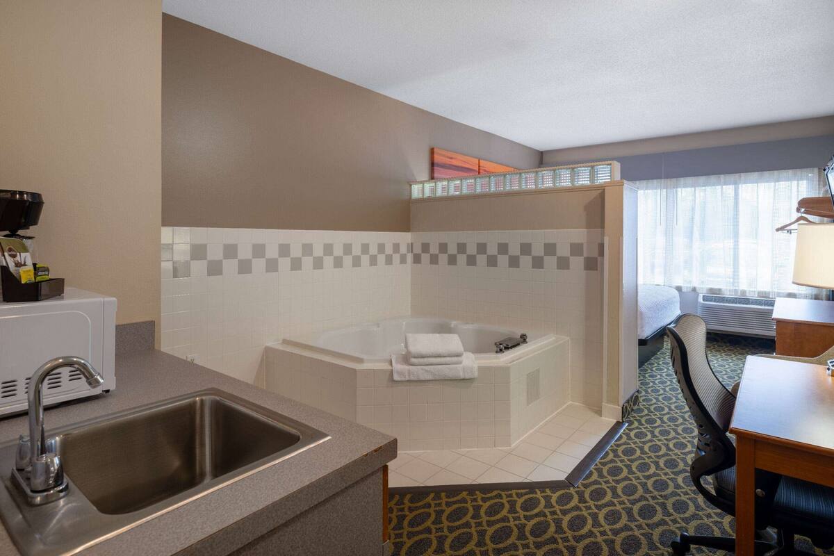 A hotel bathroom with a sink, a bathtub, and a shower.