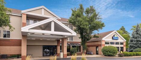 Ein Days Inn Hotel mit zweistöckiger Bauweise, überdachter Einfahrt und Parkplatz.