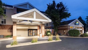 A hotel with a covered entrance, a brick facade, and a sign for Days Inn & Suites.