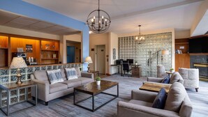 A spacious lobby with a coffee station, seating area, and a TV.