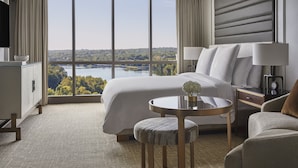A hotel room with a large window, a bed, a round table, and a chair. - Four Seasons Hotel Austin (Austin)