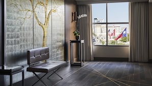 A modern room with a large window, a bench, a wall-mounted plant, and a decorative tree mural. - Four Seasons Hotel Austin (Austin)