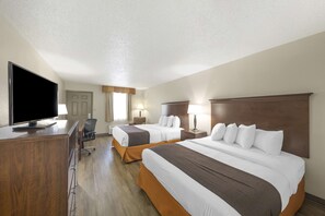 A hotel room with two beds, a desk with a flat-screen TV, and a chair.