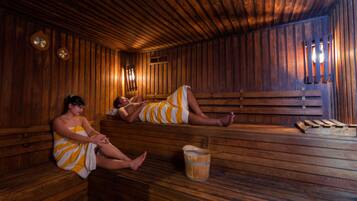Een houten sauna met banken en een houten emmer.