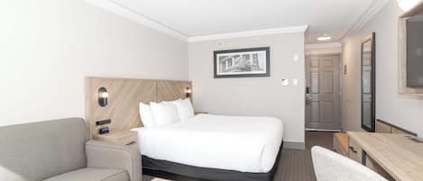 Una habitación de hotel con una cama, un sofá, un escritorio y un espejo.
