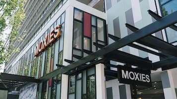A modern building with a prominent 'MOXIES' sign on the facade.