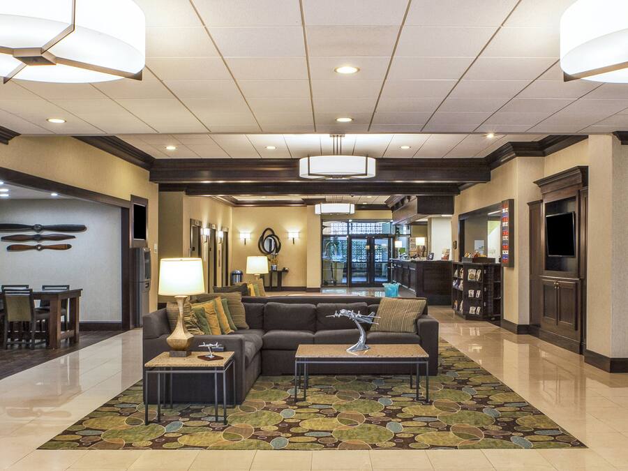 A hotel lobby with a reception desk, seating area, and a television.