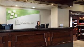 A reception desk with a modern design, a digital screen, and a sign indicating 'Holiday Inn Express'.