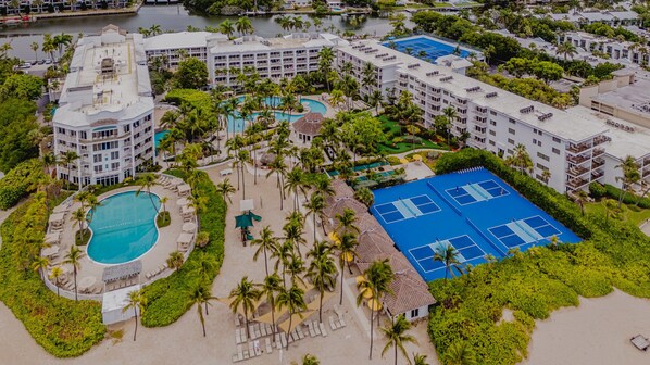 A resort with multiple swimming pools, tennis courts, and lush greenery. - Lago Mar Beach Resort & Club (Fort Lauderdale)