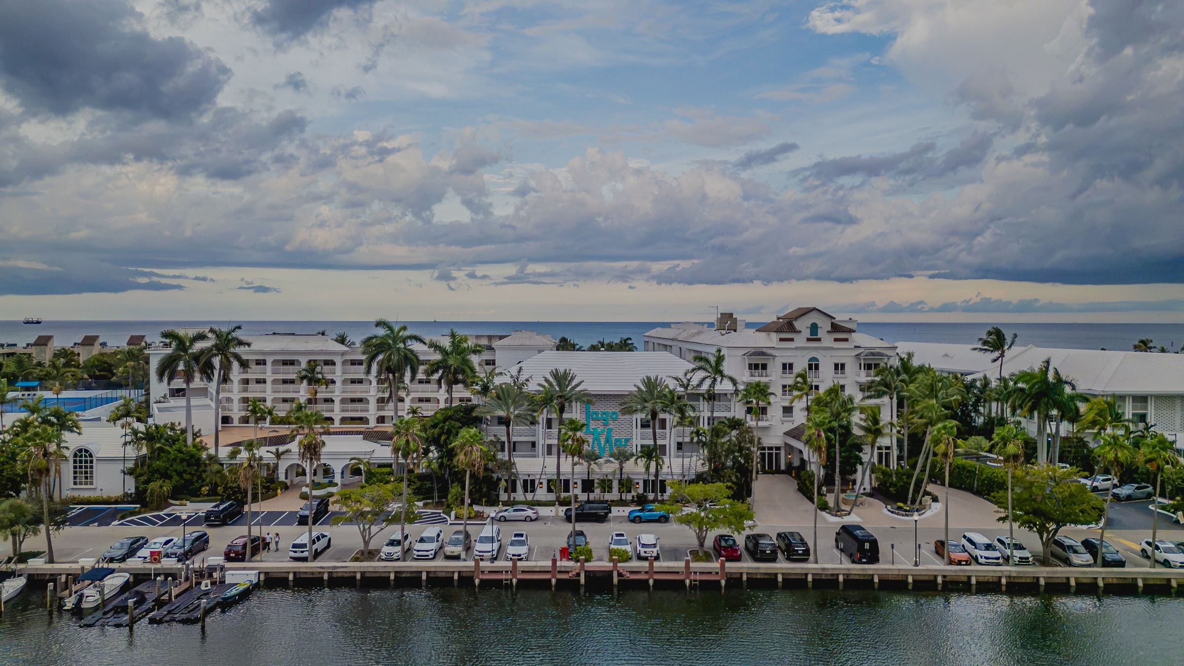 A coastal hotel with multiple buildings, a marina, and a view of the ocean.