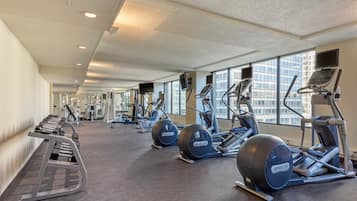 A gym with treadmills, elliptical machines, and weight machines.