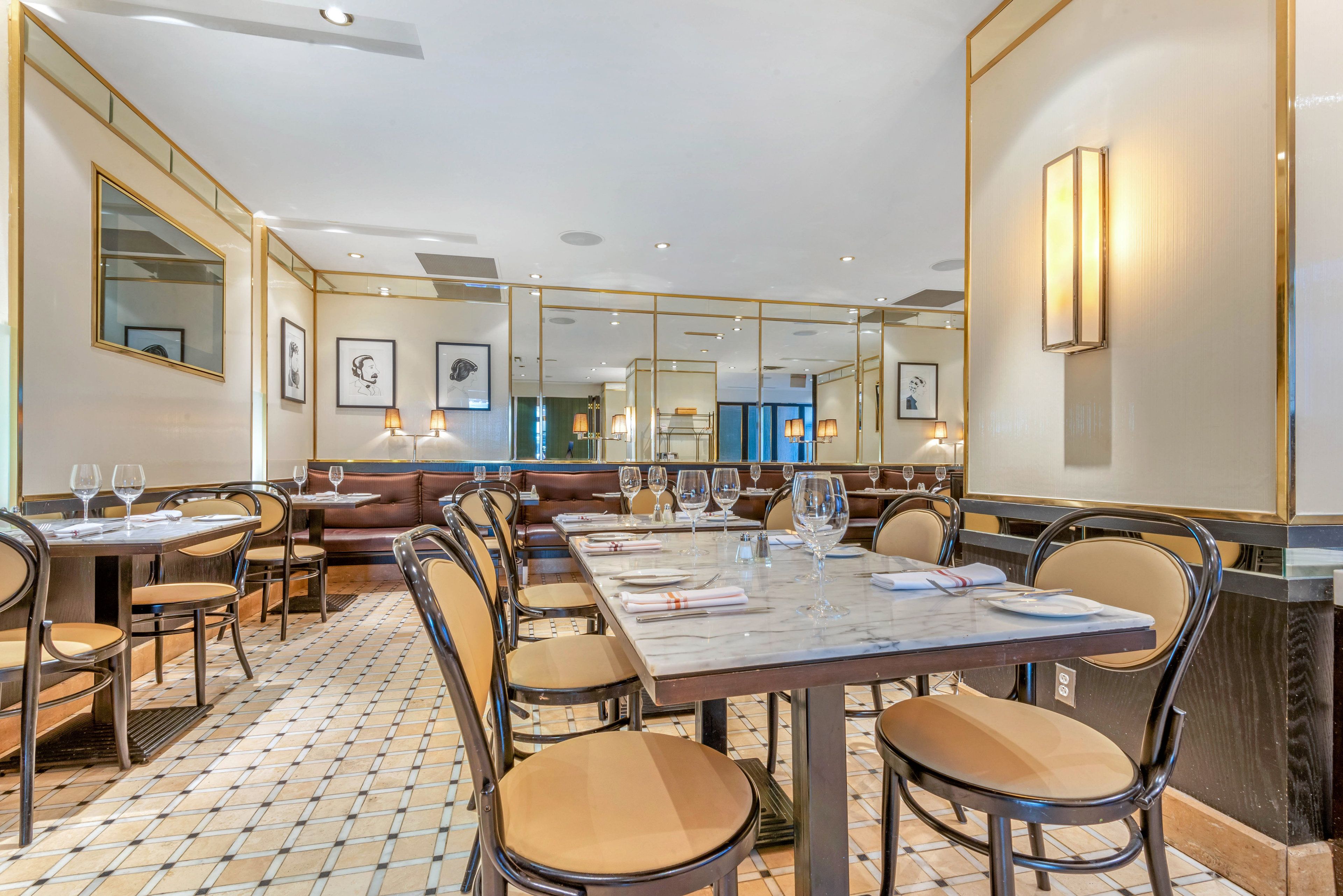 A restaurant with a long dining table, multiple booths, and a patterned floor.