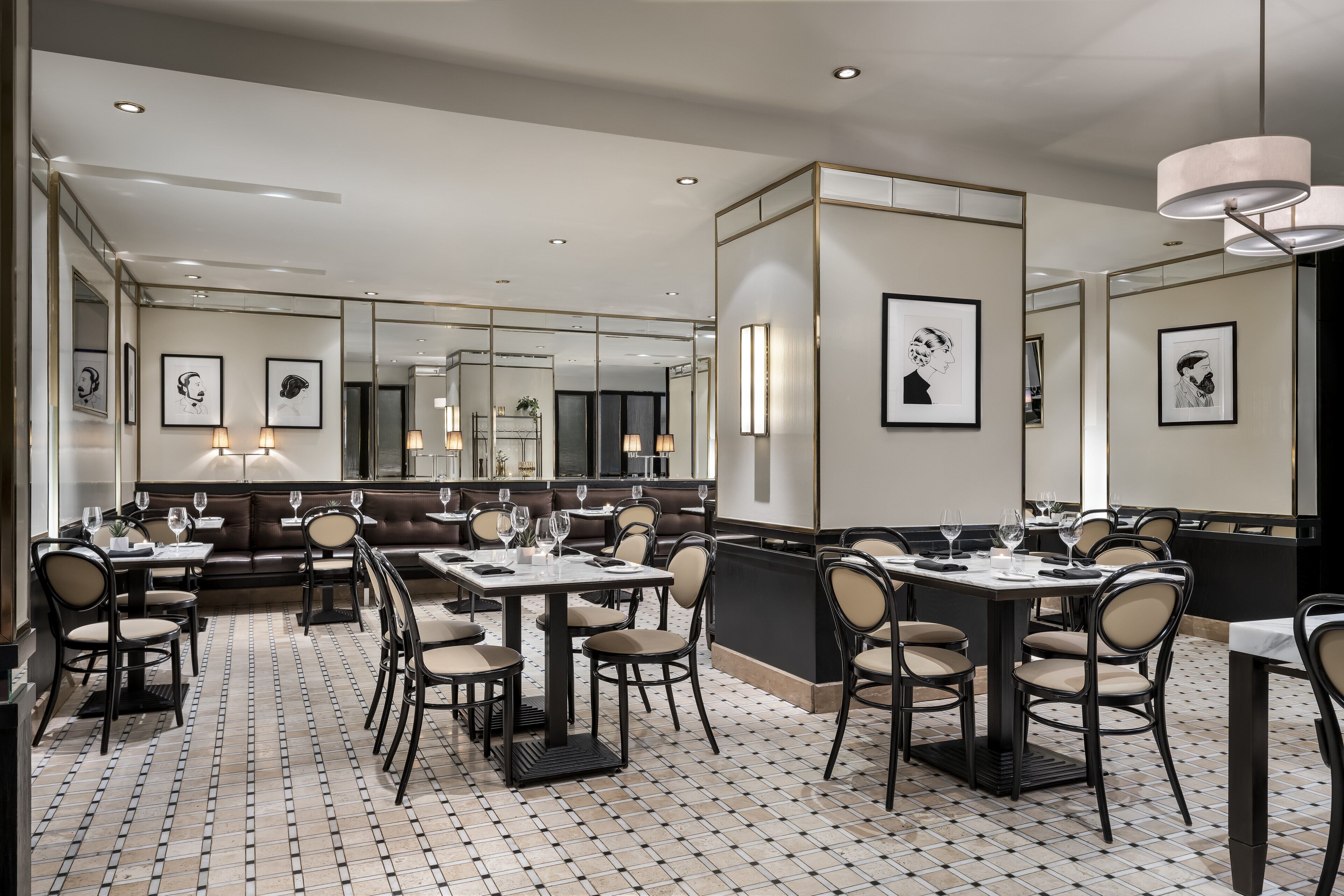A modern dining area with a mix of booth and table seating, a patterned floor, and framed artwork on the walls.