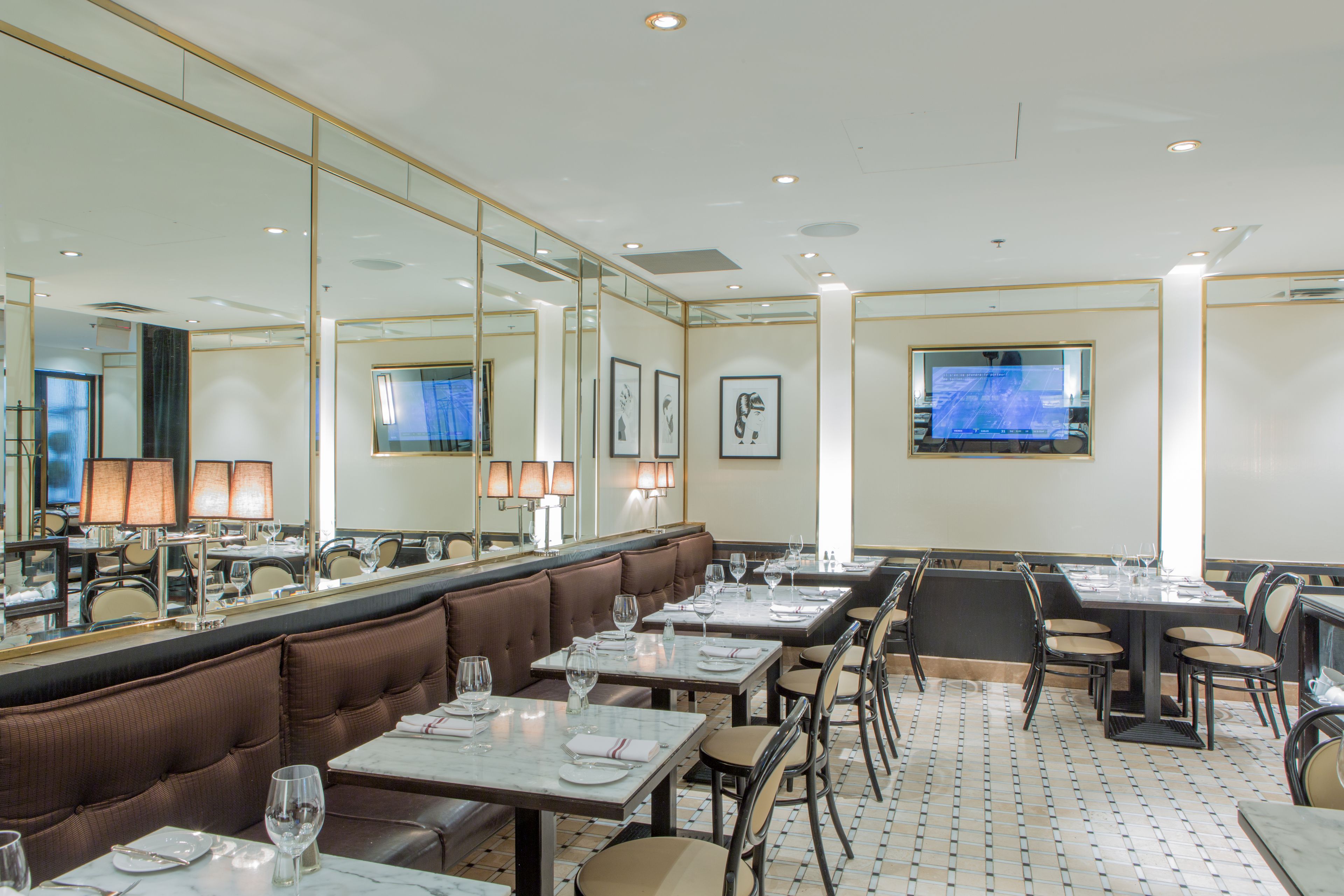 Ein Restaurant mit Sitzgelegenheiten in Form von Boxsitzgruppen und Tischen, komplett mit Geschirr und Gläsern.