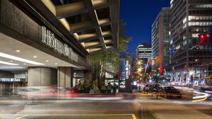 A modern hotel with a prominent entrance, large windows, and a well-lit facade.