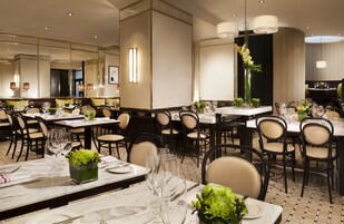 A restaurant with multiple tables set for dining, each with chairs and glassware.