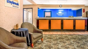 A Daybreak breakfast area with a reception desk, chairs, and a clock. - Days Inn & Suites by Wyndham Albuquerque North (Albuquerque)