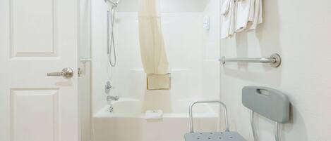 A bathroom with a shower, a toilet, and a grab bar.