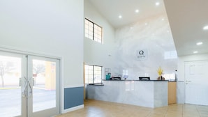 A reception area with a marble counter, a glass door entrance, and a large window. - Quality Inn Holbrook near Petrified Forest (Holbrook)