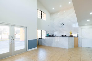 A reception area with a marble counter, a glass door entrance, and a large window. - Quality Inn Holbrook near Petrified Forest (Holbrook)
