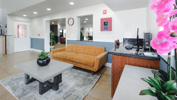 A spacious lobby with a reception desk, a sofa, a coffee table, and a potted plant. - Quality Inn Holbrook near Petrified Forest (Holbrook)