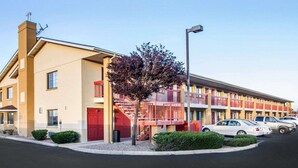 A modern hotel with a two-story structure, a red staircase, and a parking lot with several cars. - Quality Inn Holbrook near Petrified Forest (Holbrook)