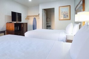 A hotel room with two beds, a television, a desk, and a painting on the wall. - Quality Inn Holbrook near Petrified Forest (Holbrook)