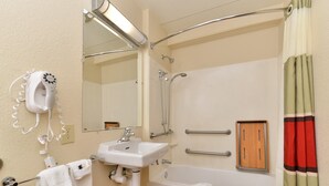 Un baño con lavamanos, espejo, toallero, ducha y un panel de madera.