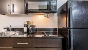 A kitchen with stainless steel appliances, including a microwave, coffee maker, and toaster. - Studio 6 Fort Worth, TX - West Medical Center (Fort Worth)